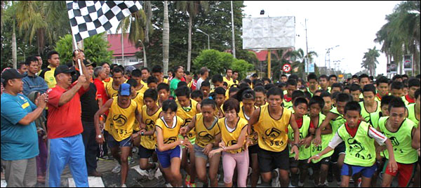 Plt Sekkab Kukar Edy Damansyah mengangkat bendera start saat melepas peserta Kukar 10 K