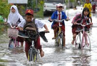 Sejumlah pelajar SD melintasi Jalan Danau Melintang yang telah terendam air 