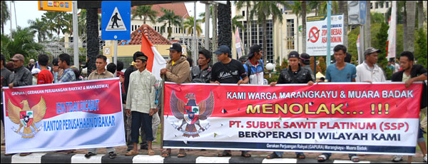 Warga membentangkan spanduk berisi penolakan terhadap PT SSP yang beroperasi di Muara Badak dan Marang Kayu 