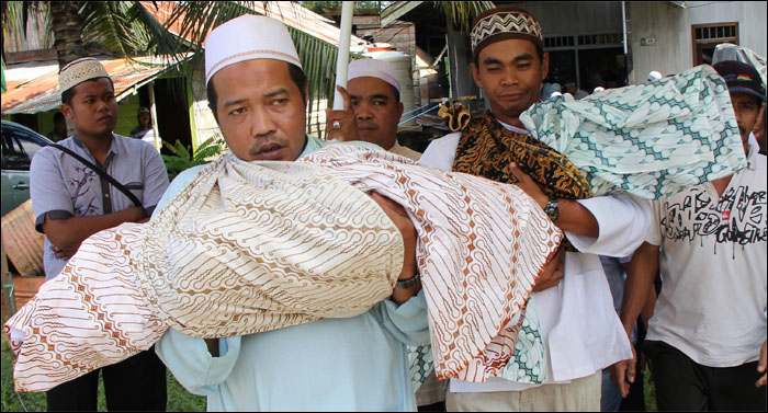 Ayah korban, Rustam Efendi (kanan), bersama ayah tiri istrinya membawa jenazah Rista dan Reisya ke pemakaman yang tak jauh dari tempat tinggal mereka