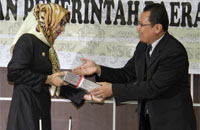 Bupati Rita Widyasari saat menerima laporan hasil penilaian LKPD Tahun 2014 dari Plh Kepala BPK RI Perwakilan Provinsi Kaltim Zainal Abidin