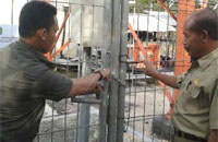 Petugas TP3MT melepas gembok di pintu pagar tower milik PT XL Axiata Tbk yang sempat disegel pekan lalu