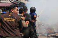 Petugas pemadam dibantu para relawan berupaya melakukan pendinginan setelah berhasil menjinakkan api