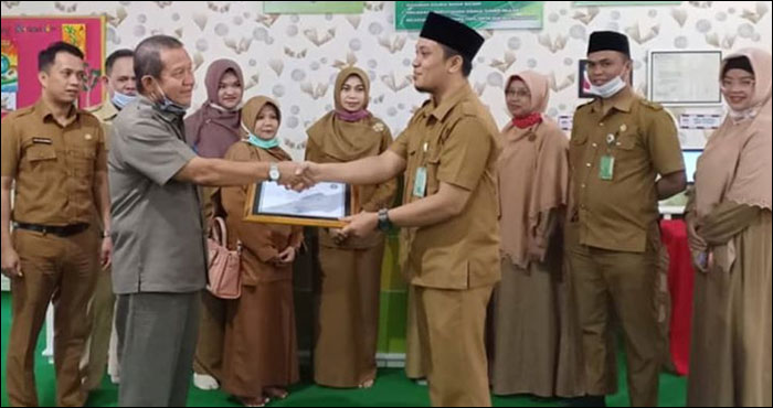 Kepala Diarpus Kukar Aji Hasanuddin menyerahkan sertifikat akreditasi dari Perpusnas RI kepada Kepala SD Muhammadiyah 1 Tenggarong Arqam Kadir Lamahu