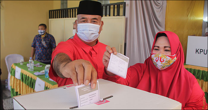 Bupati Kukar Edi Damansyah dan istri saat memasukkan surat suara di dalam kotak yang disediakan