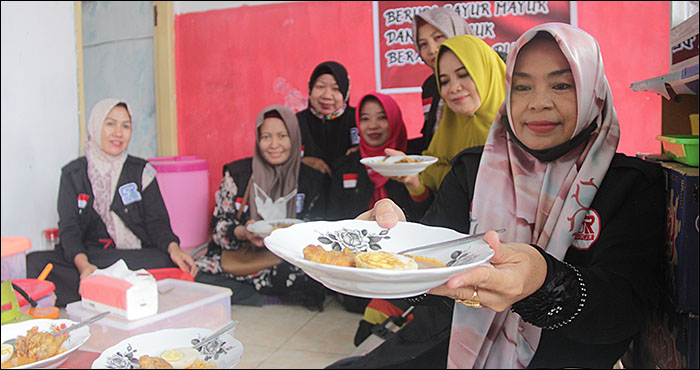 Anggota Gerakan Sedekah Rombongan Kukar menyuguhkan hidangan yang siap disantap secara cuma-cuma ada di Rumah Makan Gratis, Jalan Danau Melintang No 80, Tenggarong