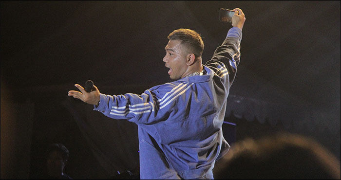 Sambil menyanyi, Fabio Asher mengabadikan momen di atas pentas SetiaFest 2022 dengan ponselnya