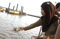 Istri mendiang Supriadi, Sulastri, menaburkan bunga di tepian sungai Mahakam 