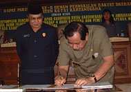 Bupati Drs H Syaukani HR MM menandatangani berita acara pengesahan 4 Perda disaksikan Ketua DPRD Kukar H Bachtiar Effendi