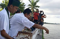 Ketua HMI Kukar Irfan Tanthawi dan Wakil Ketua KAHMI Kukar Marwan saat melakukan tabur bunga di tepian sungai Mahakam