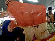 istri pejuang Merah Putih Sanga-Sanga, Ny Kapsah (kiri) , bersama anak keduanya Akhmad membentangkan bendera Merah Putih bersejarah