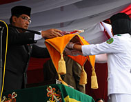 Plt Sekkab HM Aswin menyerahkan Sang Merah Putih kepada seorang anggota Paskibra Kukar pada upacara peringatan HUT Kemerdekaan RI ke-63