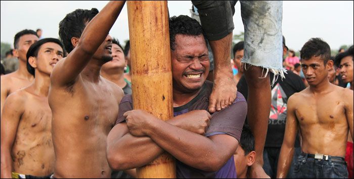 Ekspresi dan kerja keras para peserta untuk menaklukkan batang pinang yang licin membuat para penonton tertawa geli