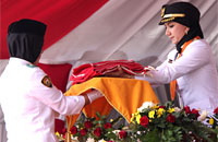 Bupati Kukar Rita Widyasari menyerahkan Sang Merah Putih kepada Jihan Laily Salsabila, anggota Paskibraka Kukar 2016 dari SMAN 1 Muara Muntai