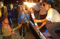 Camat Muara Kaman H Surya Agus menyalakan obor secara simbolis kepada salah seorang peserta Baris Obor