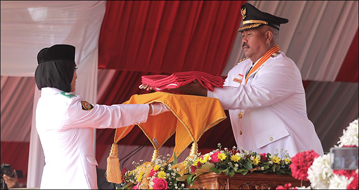 Bupati Kukar Edi Damansyah menyerahkan Sang Saka Merah Putih kepada petugas Paskibraka Kukar 2019 untuk dikibarkan satu tiang penuh