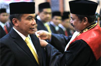 Ketua PN Tenggarong Kartim Haeruddin (kanan) menyematkan pin anggota DPRD Kukar 2014-2019 kepada H Salehudin