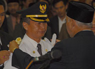 Gubernur Kaltim H Awang Faroek Ishak memasang tanda jabatan Pj Bupati Kukar kepada Sjachruddin