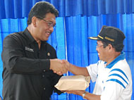 Sekkab HM Aswin (kiri) menyerahkan bantuan uang Rp 197 juta kepada Kades Loa Duri Ilir