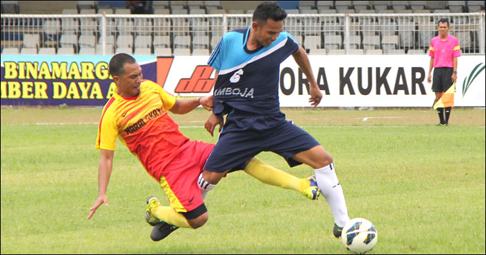 Pemain Marang Kayu (kuning-merah) menjegal pemain Samboja. Dalam laga kedua Grup I, Samboja berhasil mengalahkan Marang Kayu dengan skor telak 3-0