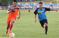 Pemain belakang Loa Janan (jingga) berebut bola dengan striker Loa Kulu (biru)  
