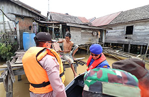 Pembagian sembako kepada masyarakat di tepian sungai Mahakam dilakukan personel TNI-Polri di Kukar