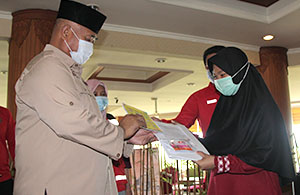 Bupati Kukar Edi Damansyah menyerahkan sertifikat dan vitamin kepada perwakilan mahasiswi Kukar yang telah menuntaskan masa karantina di Hotel Grand Elty Singgasana