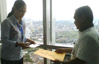 Sekretaris Diskominfo Kukar Awang Febrian Sofyan (kanan) menyerahkan surat permintaan pengurusan IMB kepada pihak ASPIMTEL di Jakarta