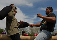 Dua peserta berusaha saling menjatuhkan dalam lomba Behempas Bantal