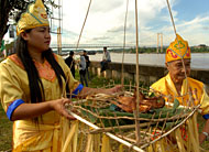 Dua orang pawang yang disebut Dewa meletakkan sesaji di atas anca bambu