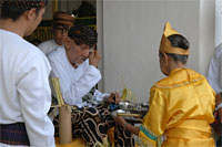 Dengan menggunakan kepingan uang logam, Sultan Kutai membasahi kedua kelopak matanya dengan air tuli