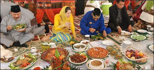 Bupati Rita Widyasari didampingi Putra Mahkota Kesultanan Kutai (pakaian biru) asyik menyantap hidangan Beseprah