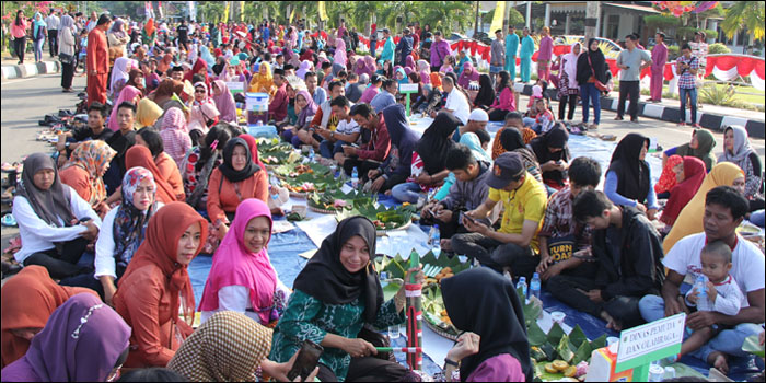 Warga dengan sabar menanti makan bersama secara Beseprah di sepanjang Jalan Mulawarman, Tenggarong