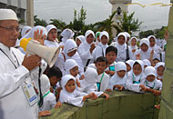 Petugas dari Kantor Depag Kukar membimbing murid TK untuk melontar jumrah
