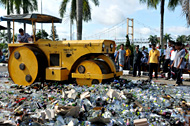 Ribuan botol dan kaleng minuman keras dari berbagai merk dimusnahkan dengan cara digilas