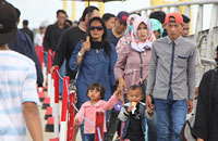 Para pengunjung berjalan menyusuri jembatan Repo-Repo menuju Pulau Kumala