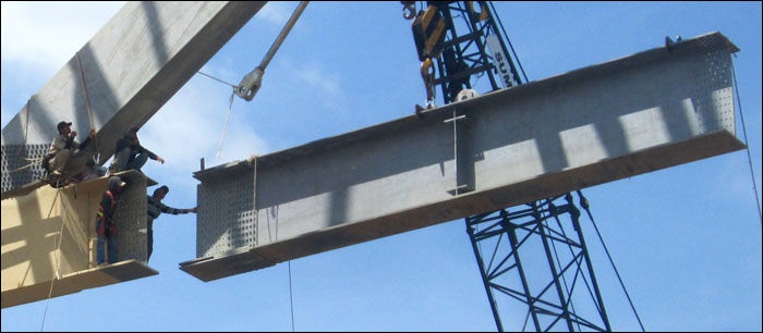 Para pekerja saat menyambut balok penyangga untuk disambungkan dengan ujung jembatan serta kabel penggantung