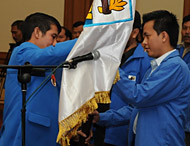Ketua KNPI Kaltim Yunus Nusi (kiri) menyerahkan bendera organisasi kepada Khairuddin selaku Ketua KNPI Kukar yang baru