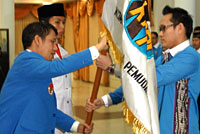 Ketua DPD KNPI Kaltim Yunus Nusi menyerahkan bendera organisasi kepada Ketua KNPI Kukar yang baru dilantik, Junaidi