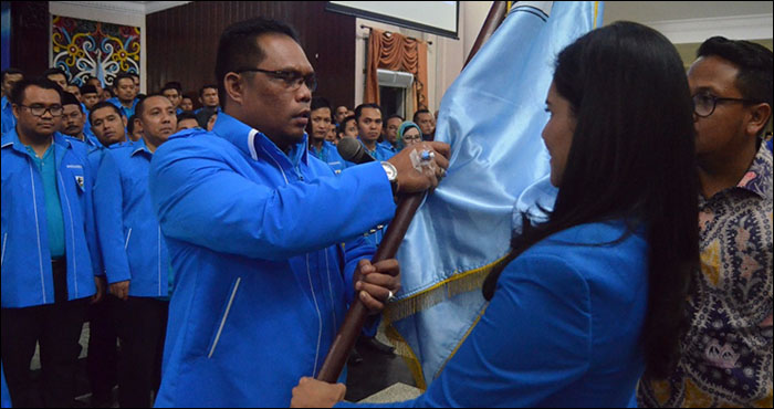 Dengan tangan yang masih dipasang jarum infus, Thauhid Afrilian Noor menerima bendera organisasi yang diserahkan Ketua KNPI Kaltim Dayang Donna Faroek