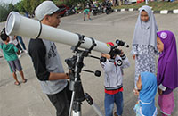 Beberapa anak mencoba mengamati matahari dengan menggunakan teropong yang disiapkan