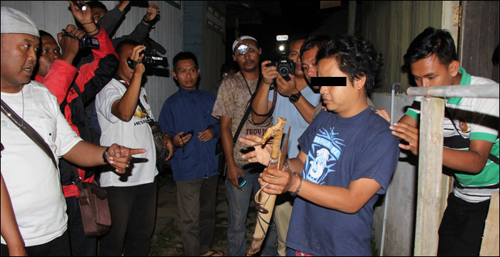 Tersangka Id saat mengambil mandau untuk memenggal kepala Ririn yang disembunyikan di rumah keluarganya di Jalan Rondong Demang, Tenggarong