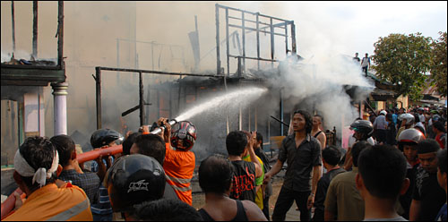 Petugas PMK dibantu warga bahu-membahu memadamkan api