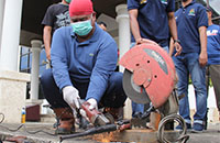 Bupati Kukar Edi Damansyah memotong laras senjata api rakitan dengan menggunakan gerinda