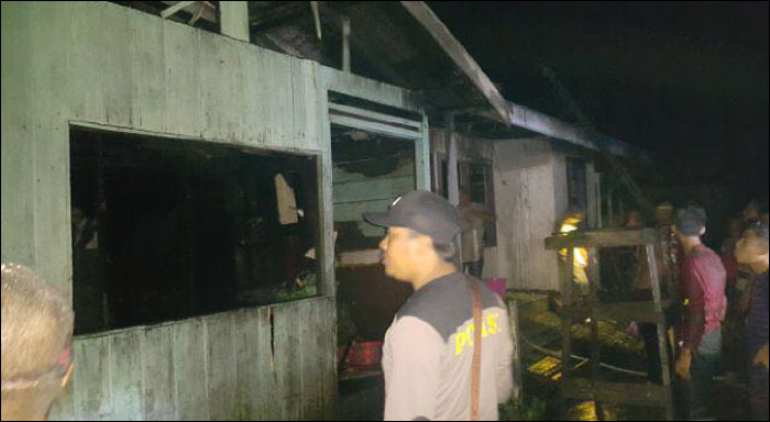 Petugas Polsek Kembang Janggut mengamankan lokasi bekas kebakaran di desa Hambau, Kamis (14/04) malam