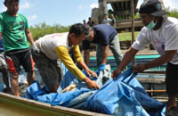 Warga bersama petugas kepolisian saat mengevakuasi mayat perempuan tanpa kepala di perairan sungai Mahakam, Kota Bangun, Selasa (04/08) siang