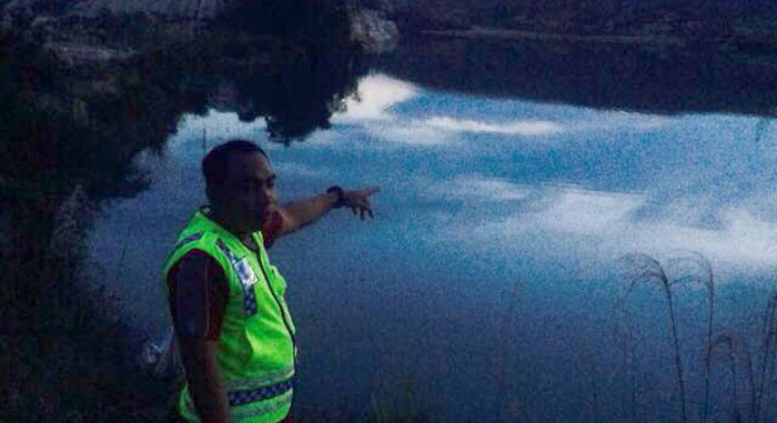 Seorang petugas Polsek Loa Janan menunjukkan lokasi tenggelamnya WIlson di sebuah danau eks tambang batubara di Loa Janan