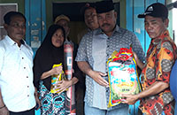 Plt Bupati Kukar Edi Damansyah menyerahkan bantuan secara simbolis kepada Ketua RT 4 Jembayan Sukri Rimpung