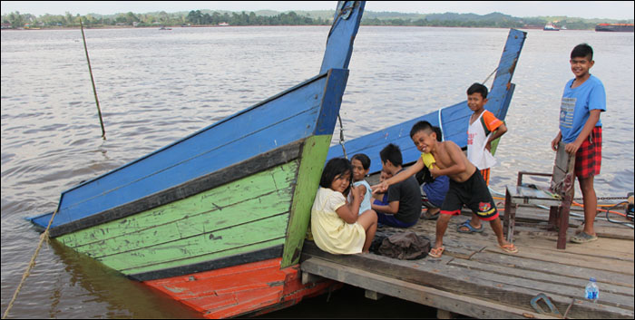 Sejumlah anak duduk bersantai di haluan kapal ferry KM Samudra yang telah diikat ke tepi dermaga Deni Putra, Desa Rempanga, Loa Kulu