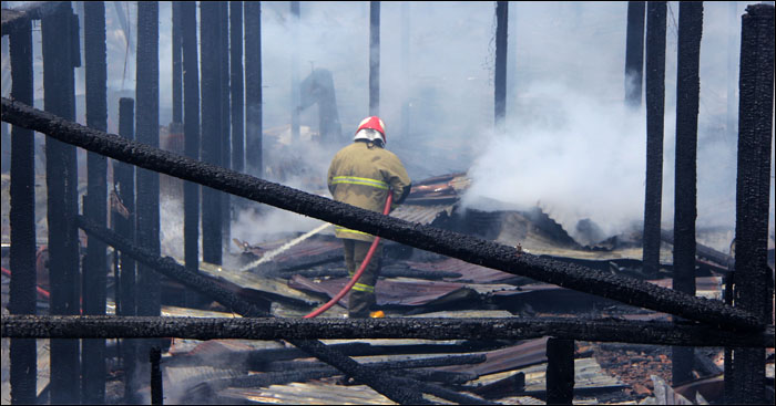 Petugas PMK melakukan pendinginan di tengah puing-puing gudang milik PT Fajar Bumi Sakti, desa Loa Ulung, Tenggarong Seberang, Rabu (04/05) siang